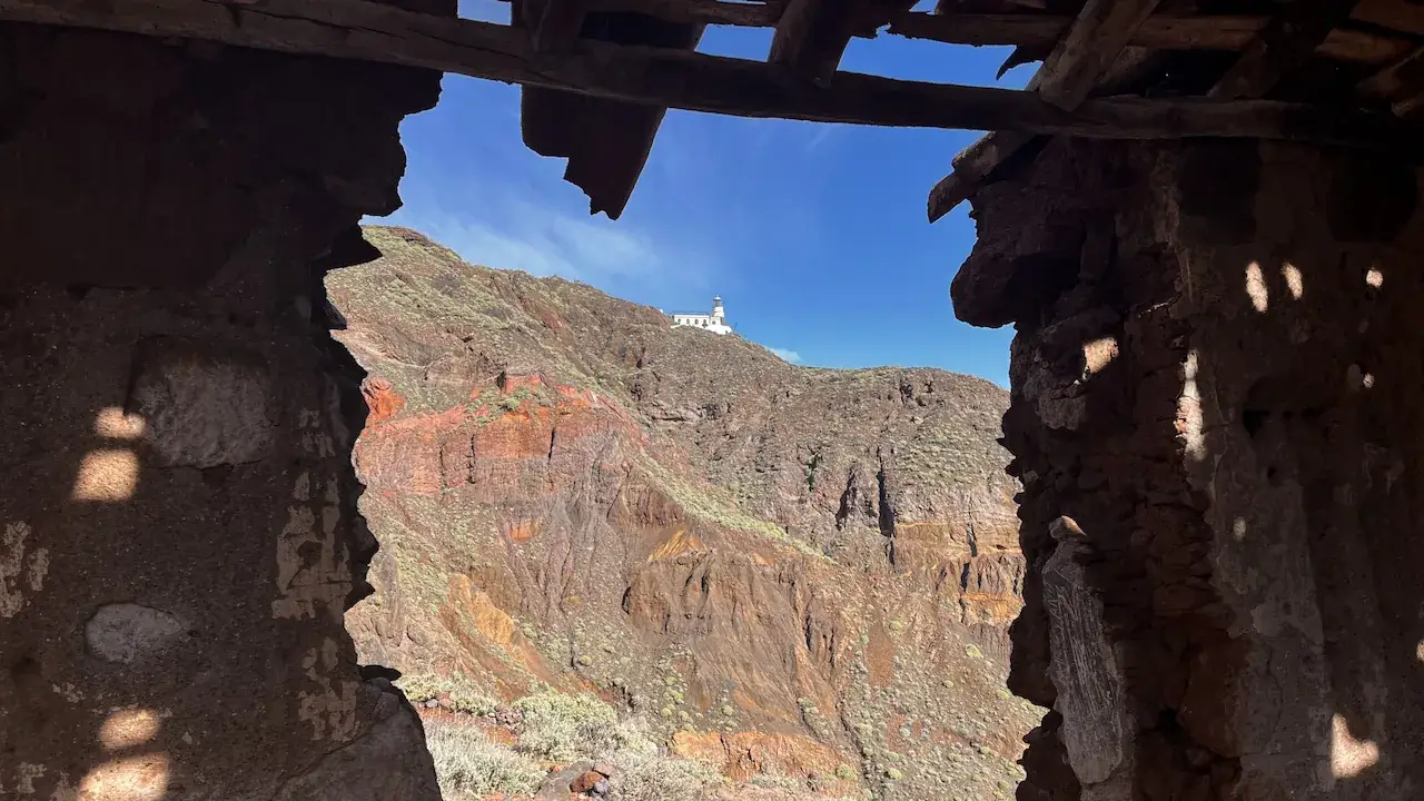View through a Casas Blancas building window at the Anaga lighthouse on the TF-6 trail in Tenerife